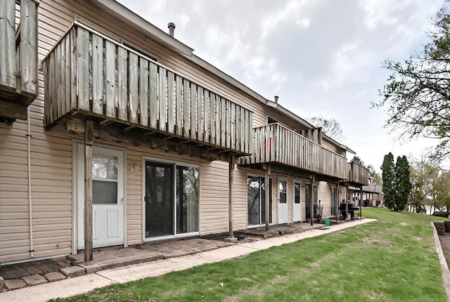 126 Cora Ave Unit D, Fox Lake, IL 60020 - rear view of house with a lawn and a balcony