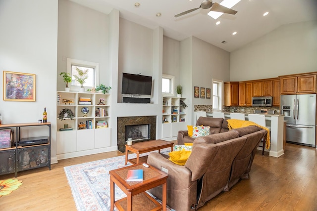 4541 N Malden St Unit 3N, Chicago, IL 60640 - living room featuring high vaulted ceiling, a fireplace, a ceiling fan, light wood-style floors, and recessed lighting