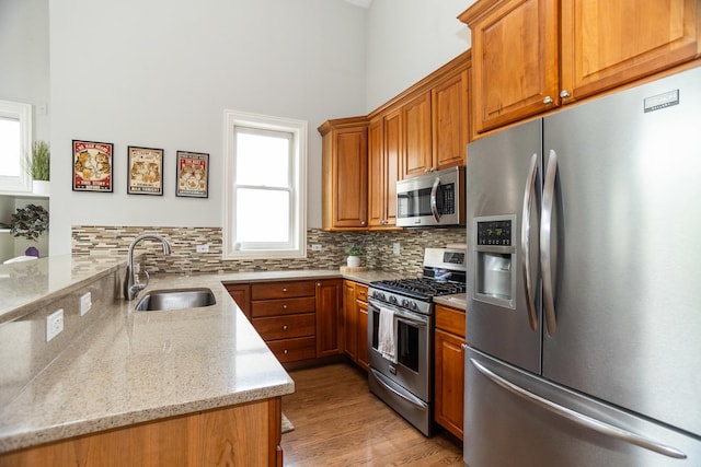 4541 N Malden St Unit 3N, Chicago, IL 60640 - kitchen featuring stainless steel appliances, a sink, a peninsula, healthy amount of natural light, and a high ceiling