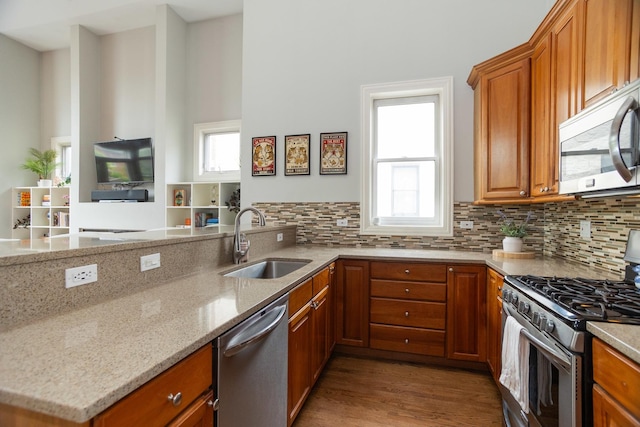 4541 N Malden St Unit 3N, Chicago, IL 60640 - kitchen with stainless steel appliances, a sink, light stone countertops, and brown cabinetry