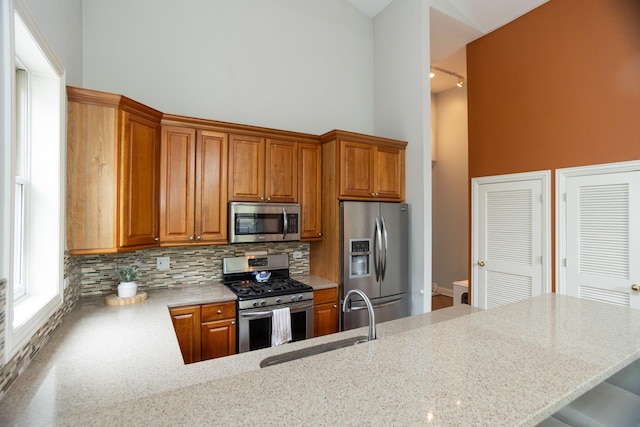 4541 N Malden St Unit 3N, Chicago, IL 60640 - kitchen with stainless steel appliances, a towering ceiling, a sink, tasteful backsplash, and light stone counters