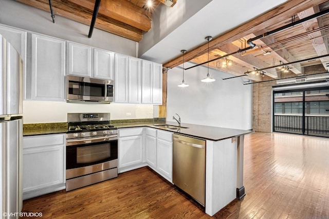 106 N Aberdeen St Unit 4F, Chicago, IL 60607 - kitchen featuring dark countertops, appliances with stainless steel finishes, dark wood-style flooring, a peninsula, and open floor plan