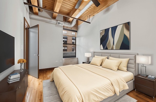 bedroom with wooden ceiling with exposed beams and wood finished floors