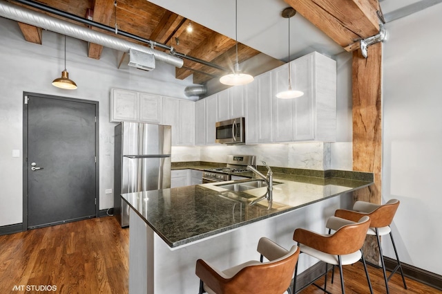 106 N Aberdeen St Unit 4F, Chicago, IL 60607 - kitchen with a peninsula, dark wood-style flooring, stainless steel appliances, white cabinetry, and beam ceiling