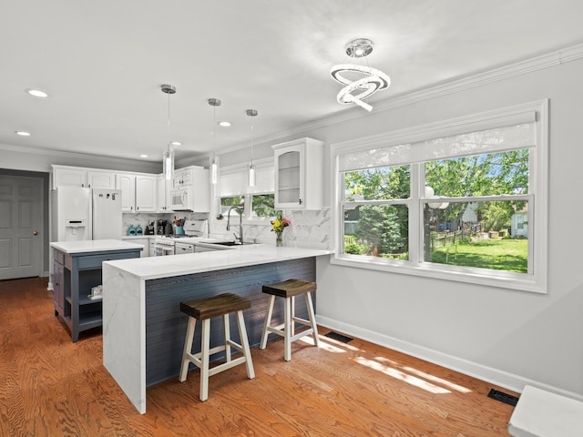 1520 Fordham Ct, Naperville, IL 60565 - kitchen featuring white appliances, a sink, ornamental molding, white cabinetry, and a peninsula