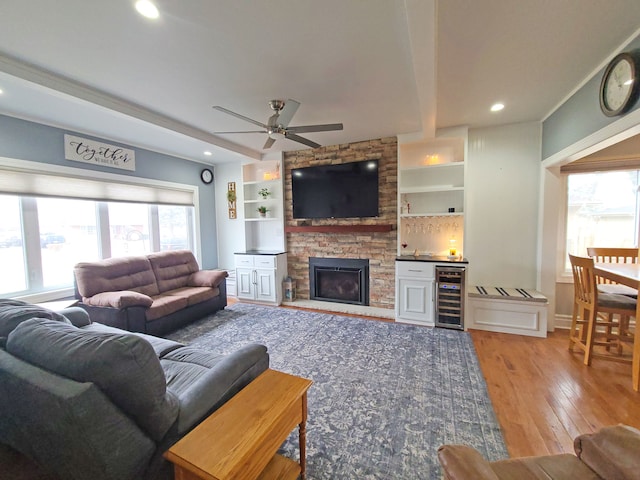 5831 W 109th St, Chicago Ridge, IL 60415 - living area featuring beverage cooler, ceiling fan, light wood-style floors, beamed ceiling, and a stone fireplace