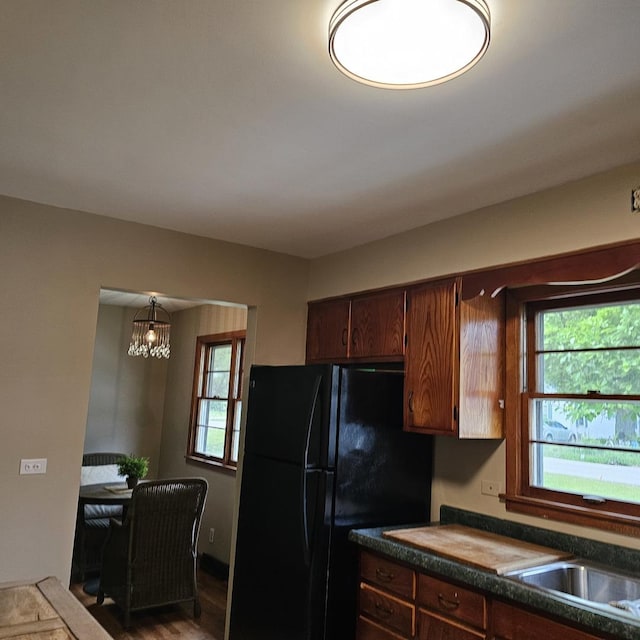 6 Johnson St, East Dundee, IL 60118 - kitchen featuring freestanding refrigerator, dark countertops, wood finished floors, and a chandelier
