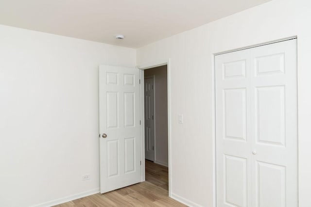 906 Central Park Dr, Round Lake Beach, IL 60073 - unfurnished bedroom featuring baseboards, light wood finished floors, and a closet