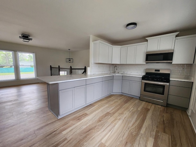 906 Central Park Dr, Round Lake Beach, IL 60073 - kitchen with stainless steel appliances, a sink, gray cabinetry, and light countertops