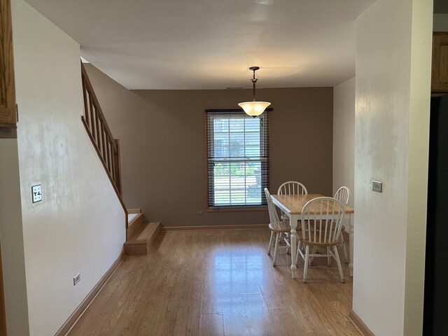 2S809 Grove Ln, Warrenville, IL 60555 - dining area featuring light wood-style flooring, stairway, and baseboards