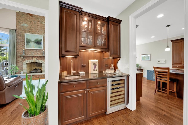 610 Greendale Rd, Glenview, IL 60025 - indoor bar featuring wine cooler, wood finished floors, a brick fireplace, hanging light fixtures, and recessed lighting