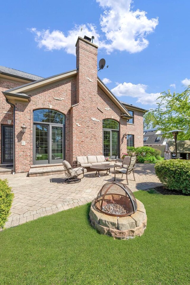 610 Greendale Rd, Glenview, IL 60025 - back of house featuring an outdoor fire pit, a patio, a chimney, a yard, and brick siding