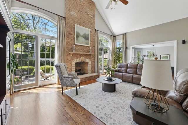 610 Greendale Rd, Glenview, IL 60025 - living area with high vaulted ceiling, healthy amount of natural light, wood finished floors, ceiling fan, and a brick fireplace