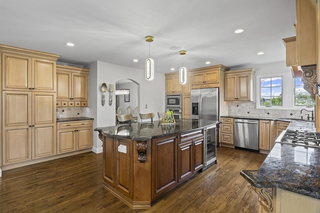 1086 Brighton Dr, Carol Stream, IL 60188 - kitchen with appliances with stainless steel finishes, dark wood-style flooring, a sink, dark stone countertops, and arched walkways