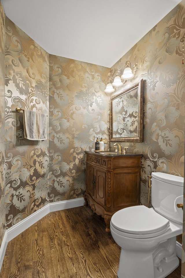 1086 Brighton Dr, Carol Stream, IL 60188 - half bathroom featuring wallpapered walls, wood finished floors, baseboards, toilet, and vanity