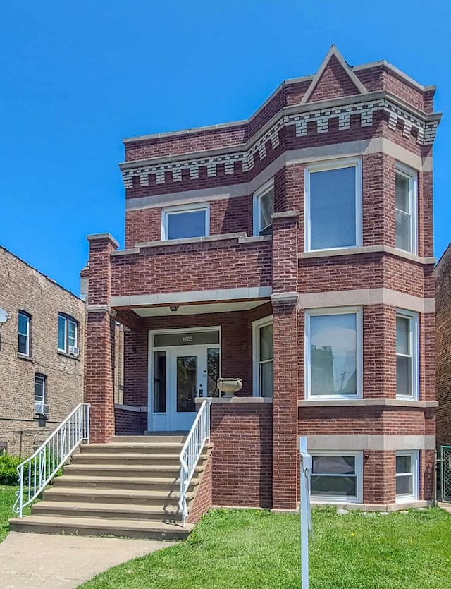 townhome / multi-family property featuring brick siding and a front lawn