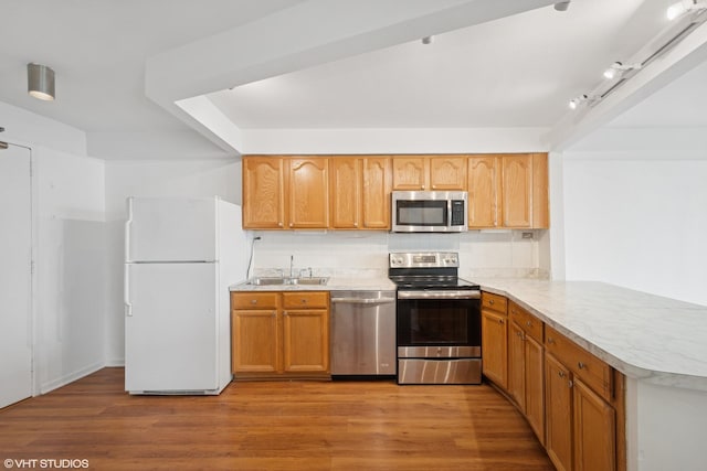 300 N State St Unit 3205, Chicago, IL 60654 - kitchen featuring appliances with stainless steel finishes, a sink, light countertops, tasteful backsplash, and a peninsula