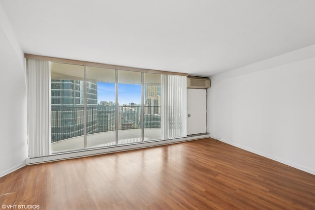 300 N State St Unit 3205, Chicago, IL 60654 - unfurnished room with wood finished floors, a wall unit AC, baseboards, and expansive windows