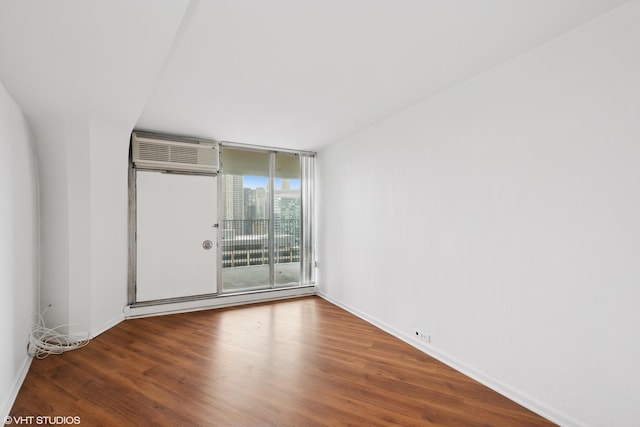 300 N State St Unit 3205, Chicago, IL 60654 - empty room with wood finished floors, a wall unit AC, a wall of windows, and baseboards
