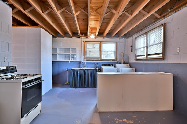 2808 Struckman Ave, River Grove, IL 60171 - kitchen featuring white gas range, concrete flooring, washing machine and clothes dryer, and concrete block wall