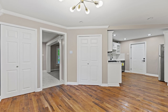 217 W Mazon Ave, Dwight, IL 60420 - kitchen featuring freestanding refrigerator, a chandelier, a sink, white cabinets, and wood finished floors