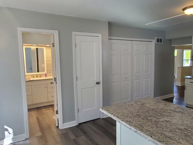 53 N Walnut St, Manteno, IL 60950 - unfurnished bedroom with dark wood-type flooring, a closet, baseboards, ensuite bathroom, and a sink