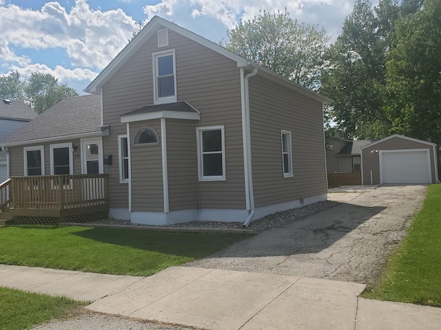 53 N Walnut St, Manteno, IL 60950 - view of front of home with asphalt driveway, an outdoor structure, a front lawn, a wooden deck, and a garage