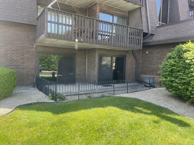 1616 Richmond Cir Unit 101, Joliet, IL 60435 - back of property with a balcony, a patio area, brick siding, and a yard