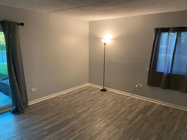 1616 Richmond Cir Unit 101, Joliet, IL 60435 - empty room with dark wood-type flooring, baseboards, and a textured ceiling