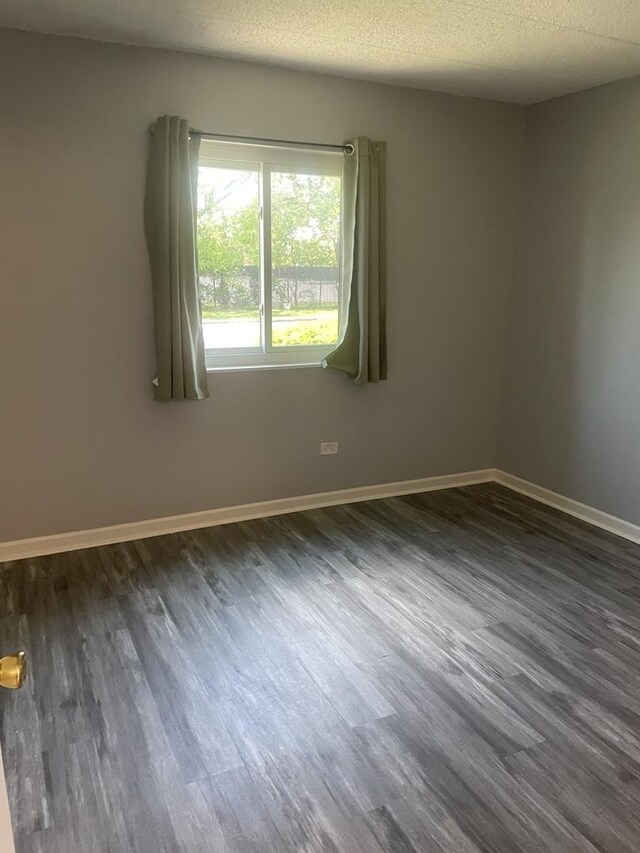 1616 Richmond Cir Unit 101, Joliet, IL 60435 - spare room featuring dark wood-style floors, baseboards, and a textured ceiling