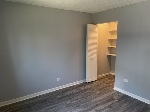 1616 Richmond Cir Unit 101, Joliet, IL 60435 - unfurnished bedroom with dark wood-style floors, a closet, and baseboards