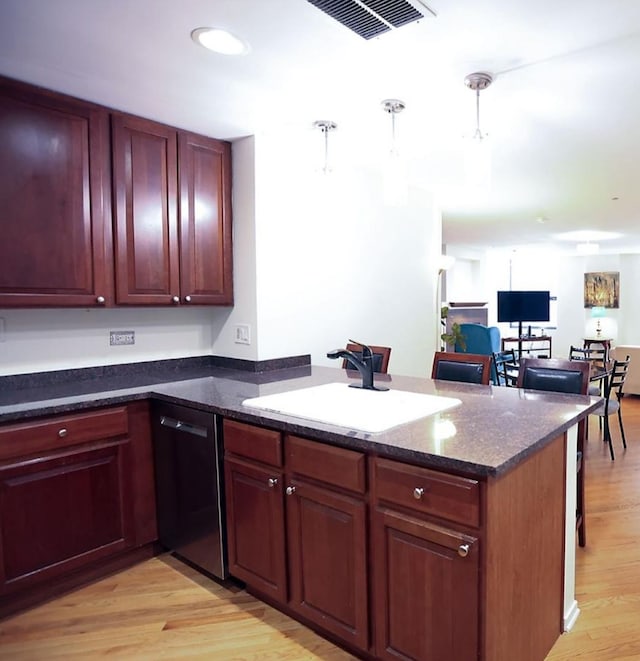 910 S Michigan Ave Unit 1805, Chicago, IL 60605 - kitchen featuring stainless steel dishwasher, a peninsula, light wood-type flooring, pendant lighting, and dark stone countertops