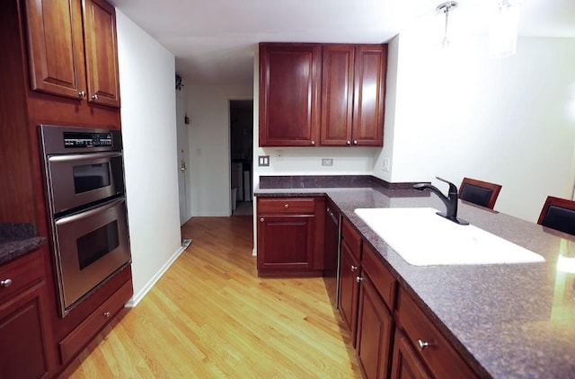 910 S Michigan Ave Unit 1805, Chicago, IL 60605 - kitchen featuring stainless steel double oven, light wood-style flooring, dark brown cabinets, and dark stone countertops