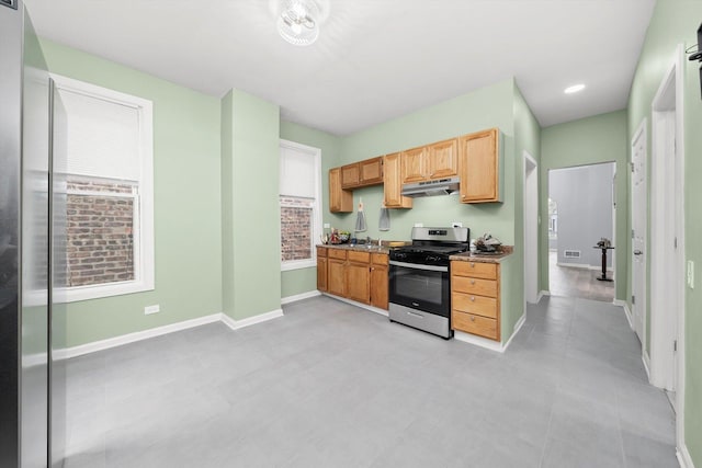 5635 S May St, Chicago, IL 60621 - kitchen with stainless steel gas stove, under cabinet range hood, baseboards, and a sink