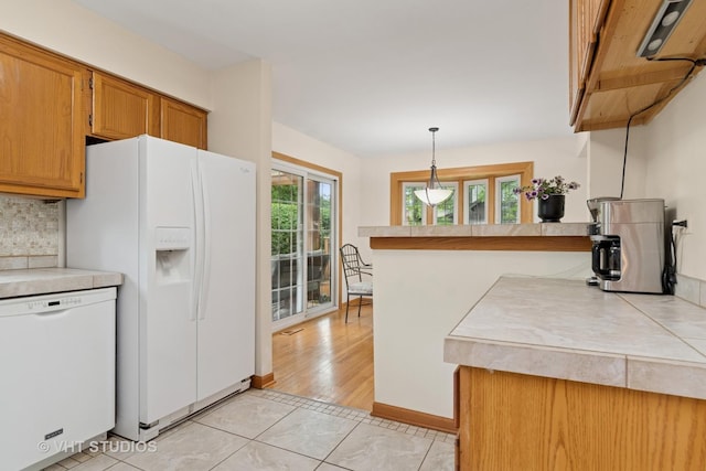 253 Waxwing Ave, Naperville, IL 60565 - kitchen with white appliances, light countertops, brown cabinetry, pendant lighting, and backsplash