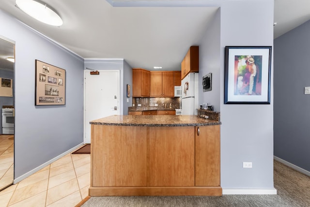 247 E Chestnut St Unit 1102, Chicago, IL 60611 - kitchen featuring white appliances, tasteful backsplash, a peninsula, light tile patterned floors, and baseboards