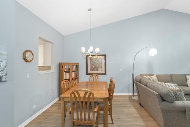 646 S Curran Rd, Round Lake, IL 60073 - dining area with vaulted ceiling, a chandelier, light wood-type flooring, and baseboards