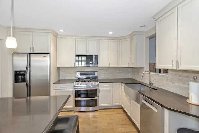 646 S Curran Rd, Round Lake, IL 60073 - kitchen featuring appliances with stainless steel finishes, dark countertops, a sink, light wood-style flooring, and recessed lighting