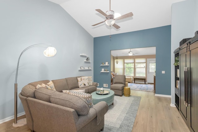 646 S Curran Rd, Round Lake, IL 60073 - living room featuring a barn door, ceiling fan, light wood-style floors, baseboards, and high vaulted ceiling