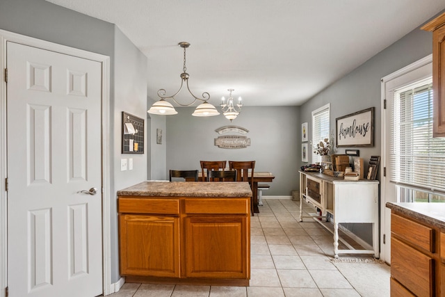 713 Sedgegrass Dr, Champaign, IL 61822 - kitchen featuring plenty of natural light, brown cabinets, a chandelier, and light tile patterned flooring