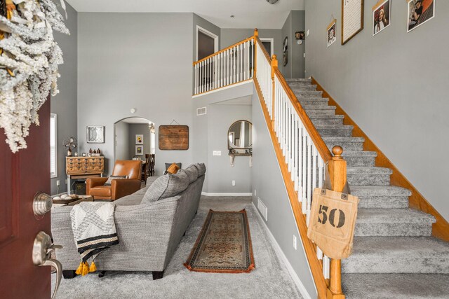 713 Sedgegrass Dr, Champaign, IL 61822 - carpeted living room with arched walkways, stairs, and a high ceiling