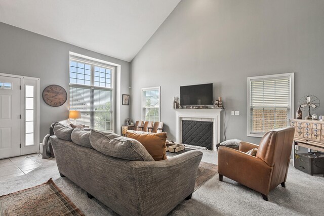 713 Sedgegrass Dr, Champaign, IL 61822 - living room with high vaulted ceiling, a tiled fireplace, and light carpet