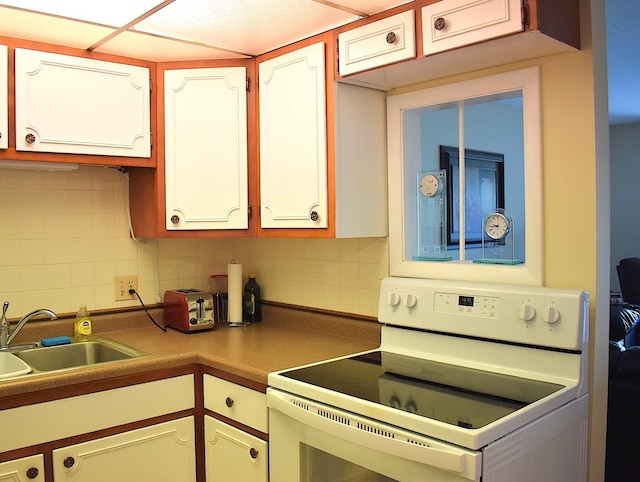 2900 Maple Ave Unit 10E, Downers Grove, IL 60515 - kitchen featuring white electric stove, a sink, decorative backsplash, and white cabinetry