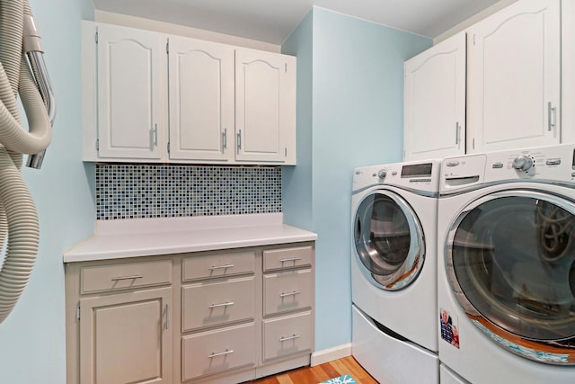 43389 N Oakcrest Ln N, Zion, IL 60099 - washroom featuring cabinet space, washing machine and dryer, and light wood-style flooring