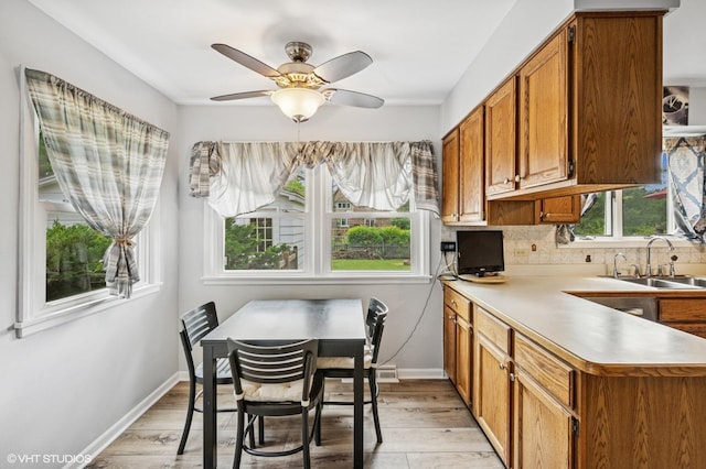 211 W Kenilworth Ave, Prospect Heights, IL 60070 - kitchen with a sink, light wood-type flooring, brown cabinets, light countertops, and a ceiling fan