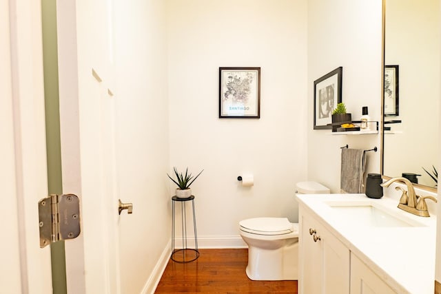 1009 Lathrop Ave, Forest Park, IL 60130 - half bathroom with vanity, toilet, wood finished floors, and baseboards