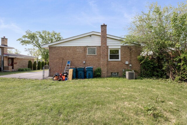 151 Amy St, Chicago Heights, IL 60411 - back of property with brick siding, a lawn, a chimney, and central air condition unit