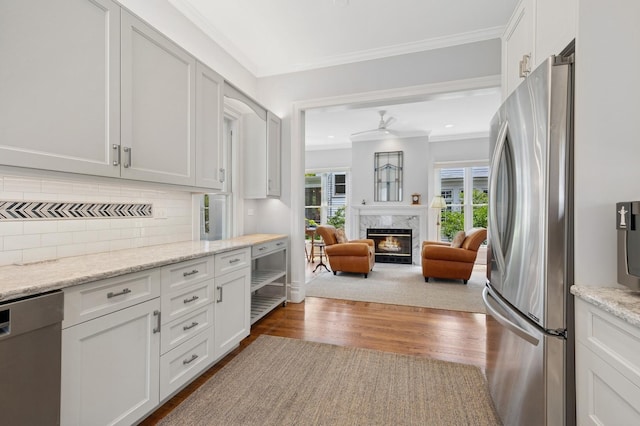 641 Michigan Ave, Evanston, IL 60202 - kitchen featuring appliances with stainless steel finishes, ornamental molding, wood finished floors, tasteful backsplash, and a fireplace