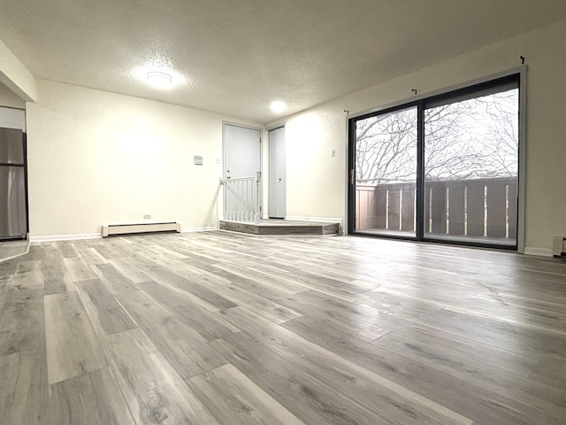 15 Echo Ct Unit 7, Vernon Hills, IL 60061 - spare room with baseboard heating, wood finished floors, a textured ceiling, and baseboards