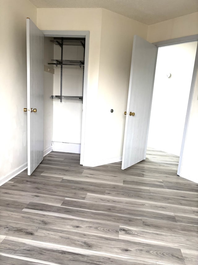 15 Echo Ct Unit 7, Vernon Hills, IL 60061 - unfurnished bedroom featuring wood finished floors, a closet, and baseboards